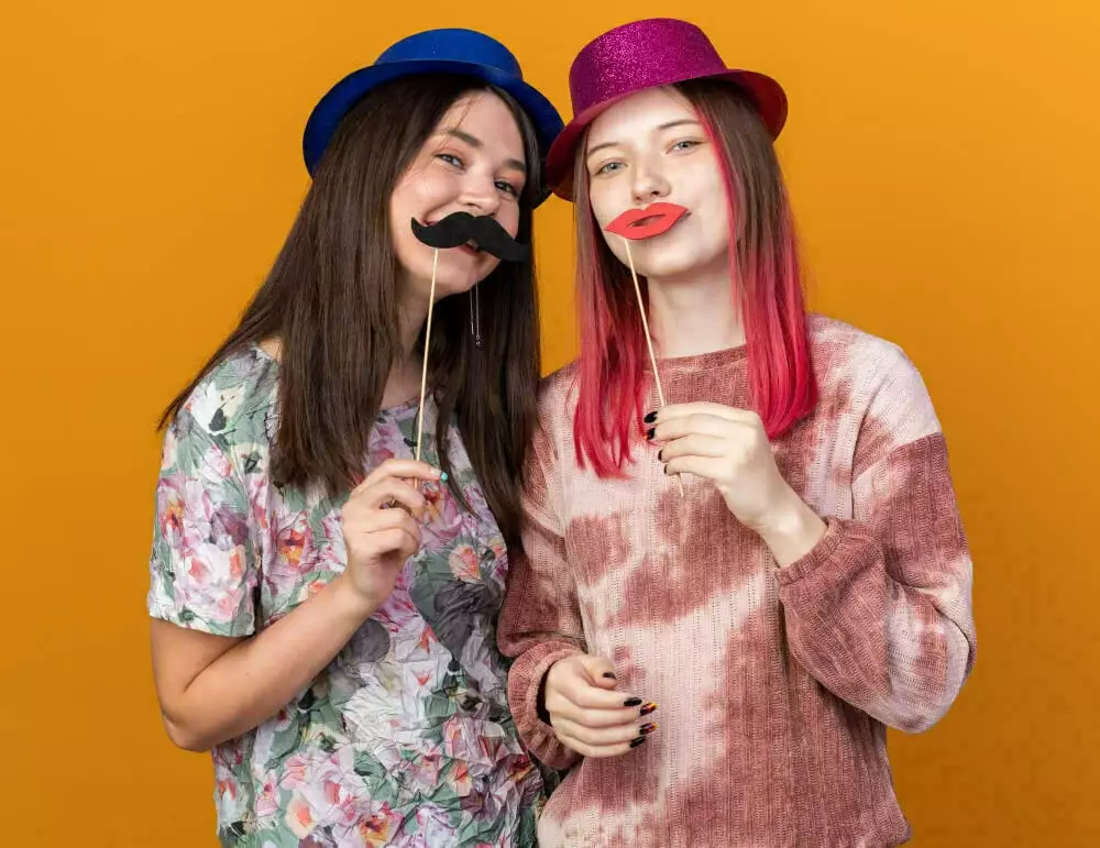 Amies utilisant des accessoires photobooth